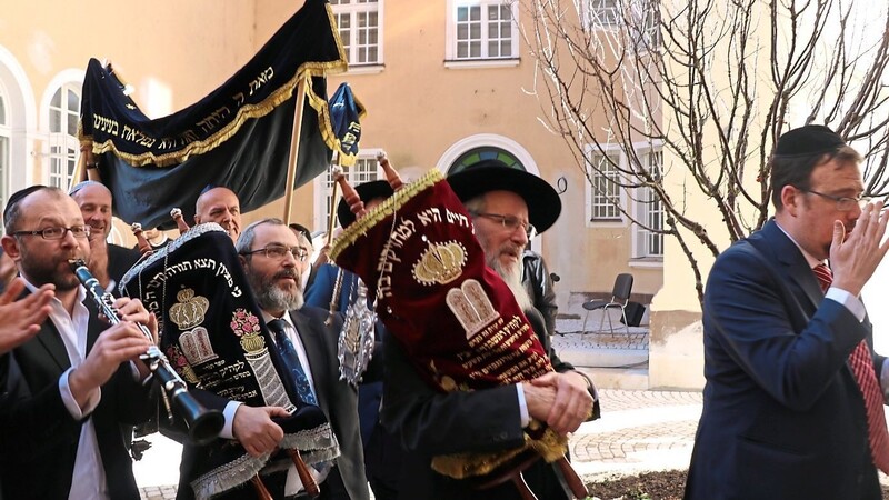 Begleitet von Musik werden die Thora-Rollen in die neue Synagoge gebracht.