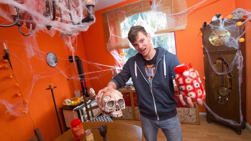 Der 23-jährige Kevin Bitter posiert mit einem Totenkopf und einem Glas mit künstlichen Augen im Wohnzimmer.