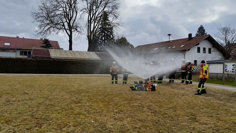 In der Haarbacher Ortsmitte üben die Teilnehmer, wie eine Mannschutz-Brause funktioniert. Im Hintergrund ist das Feuerwehrhaus zu sehen.