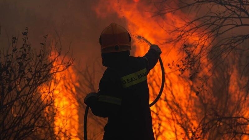 Ein Feuerwehrmann kämpft nahe Athen gegen einen Waldbrand.