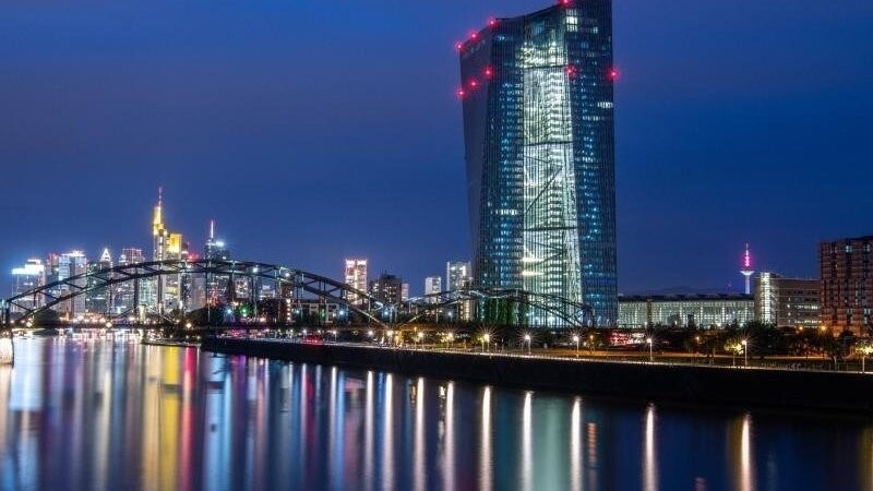 Die Lichter der Europäischen Zentralbank sowie der Frankfurter Bankenskyline spiegeln sich im Main.