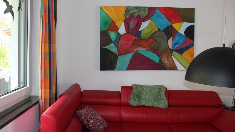Moderne Kunst hinter dem roten Sofa: Die Künstlerin passt in keine Schublade.
