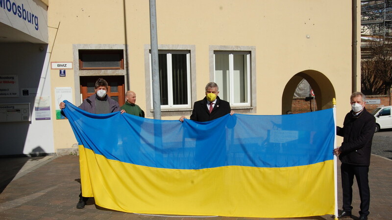 Zeichen der Solidarität: die drei Bürgermeister Michael Stanglmaier (l.), Josef Dollinger (M.) und Georg Hadersdorfer (r.) hissten vor dem Haus der Bildung die ukrainische Fahne.