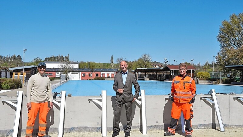 Bürgermeister Alfons Sittinger macht sich mit Schwimmmeister Josef Zitzelsberger und dem neuen Freibadmitarbeiter Julian Girschitzka ein Bild vom Einbau der Lamellenabdeckung.