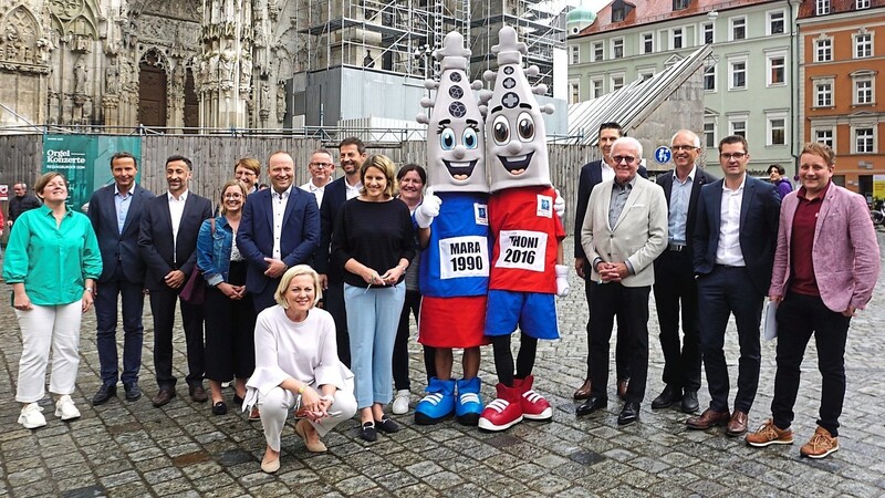 Alles ist vorbereitet für den Regensburg-Marathon 2022: Veranstalter, Sponsoren und Bürgermeisterin Astrid Freudenstein mit den Maskottchen Mara und Thoni vor dem Dom.
