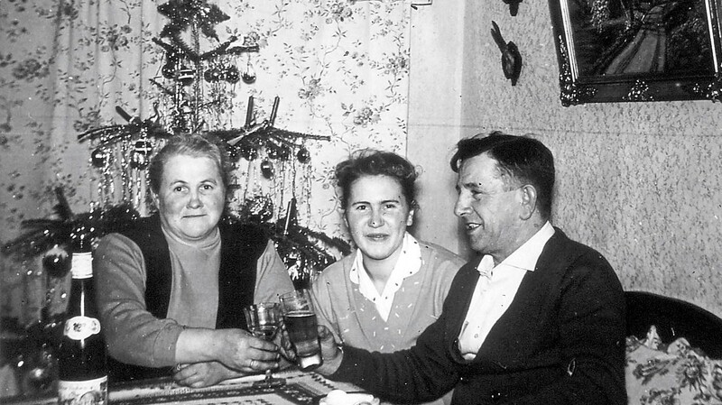 Um 1955: Herr und Frau Meidinger stoßen mit Tochter Berti auf ein schönes Fest an.
