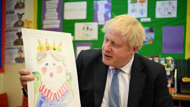 Der britische Premierminister Boris Johnson zeigt in einer Grundschule ein Porträt, das er von Königin Elizabeth II. gemalt hat. Auch die Ergebnisse der Lokalwahlen sind für ihn kein Grund, zurückzutreten.