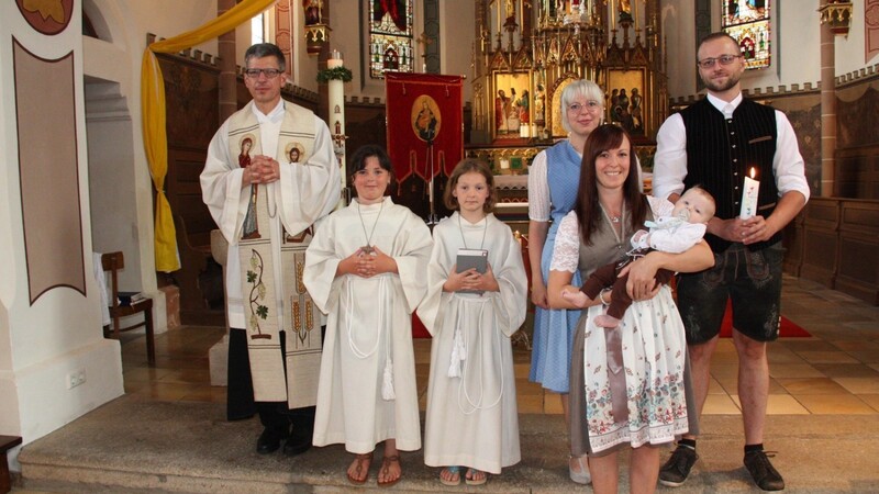 Nach der Taufe: Pfarrer Johann Wutz, die Ministrantinnen, die Eltern und die Patin mit dem Täufling.