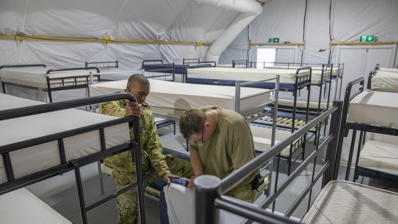 US-Soldaten bauen auf dem Truppenübungsplatz schon einmal Zelte mit Kojen und Stockbetten auf.