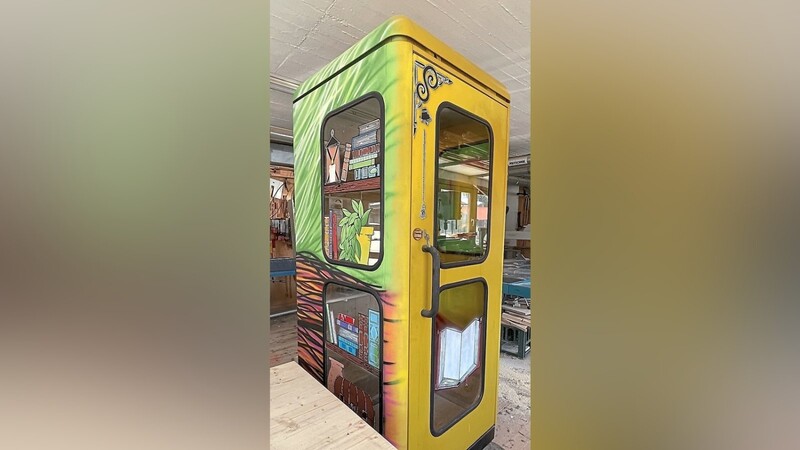 Die ehemalige Telefonzelle hat in den vergangenen Tagen einen künstlerischen Anstrich erhalten und wird vor Ort mit Büchern zum Mitnehmen ausgestattet.