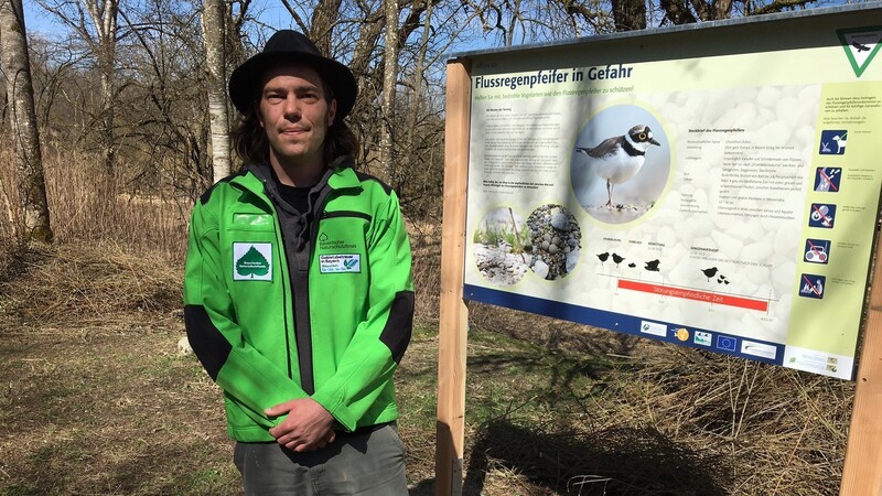 Gebietsbetreuer Fabian Hertrich mit einer der neuen Tafeln, die Sapziergänger auf die Brutmaßnahmen der gefährdeten Vogelart aufmerksam machen sollen.
