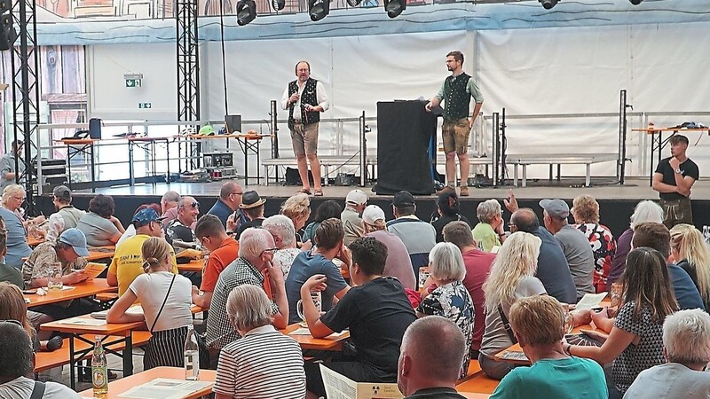 In der zur Hälfte gefüllten Festhalle Schmidt führen Auktionator Joachim Zellmeier und der Chef des Fundbüros, Markus Rengstl (auf der Bühne, von links), durch die Versteigerung.