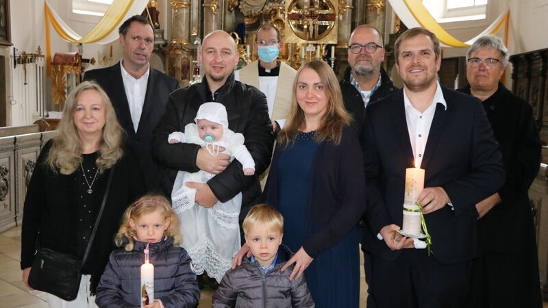 Die Taufe erhielt der vier Monate alte Hannes Eliah Nork, den sein Taufpate auf dem Arm hält. Mit im Bild die Eltern sowie Bruder Elias, die Großeltern und Kaplan Matthias Meckel als Taufspender.