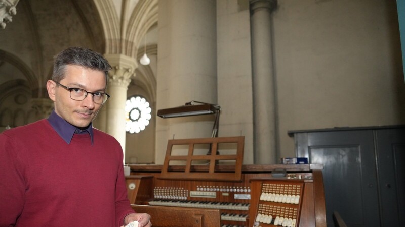 Kirchenmusikdirektor Tobias Frank zeigt, was an der Orgel repariert werden muss: Die Registerzüge aus Zelluloid lösen sich förmlich auf.