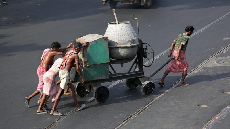 Indische Arbeiter ziehen am 28. Mai 2015 in Kalkutta (Indien) einen Zementmixer über eine Straße. Weltweit gibt es laut einer Studie mehr als 45 Millionen Sklaven.