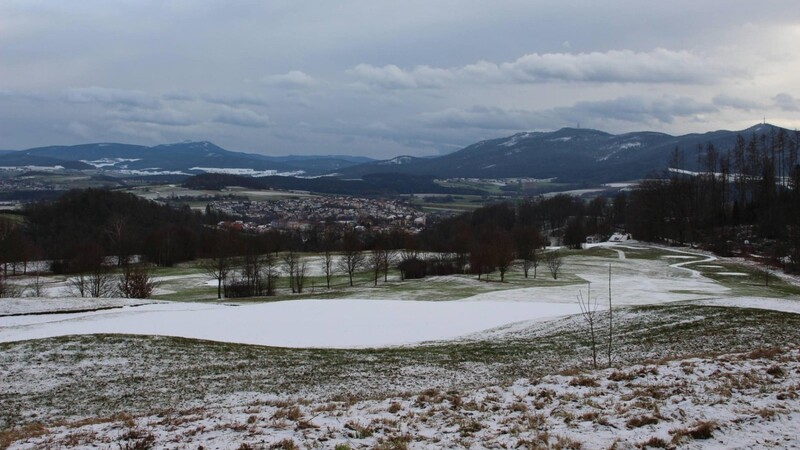 Blick vom mit Schnee überzuckerten Golfplatz nach Furth im Wald mit dem Osser und Hohenbogen dahinter.