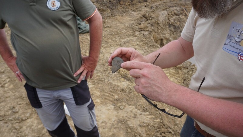 Kreisarchäologe Dr. Eibl und Grabungsleiter in Eichendorf, Dr. Piller, erörtern ein Bruchstück eines Gefäßes aus der Hallstattzeit (ca. 800-500 v.Chr.), welches nur wenige Stunden zuvor in einem der großen Gräben vor Ort gefunden wurde.