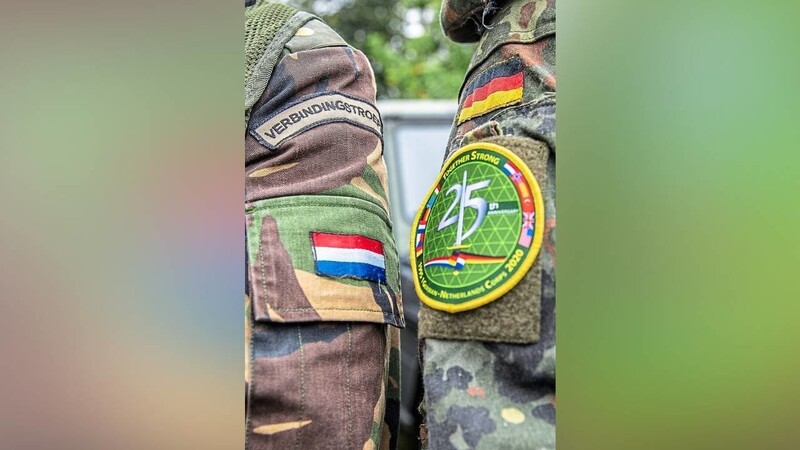 Ein niederländischer und ein deutscher Soldat stehen im Rahmen des bereits Deutsch-niederländischen Korps nebeneinander.