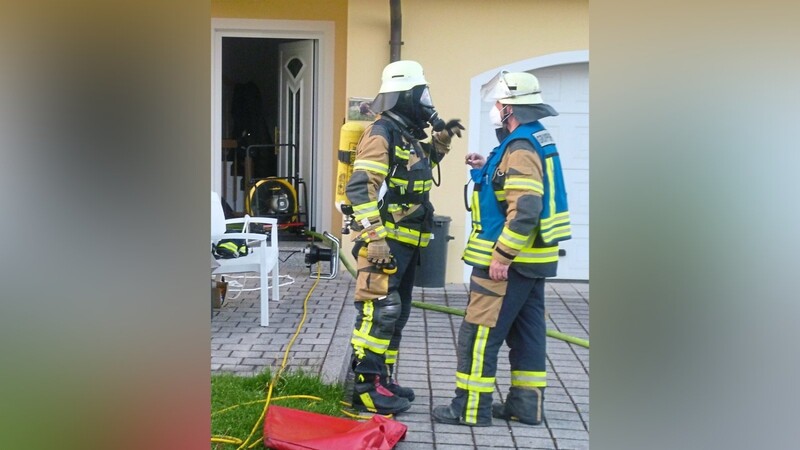 Einsatzbesprechung: Ein Ventilator (links hinten) bläst den Rauch aus dem Haus.