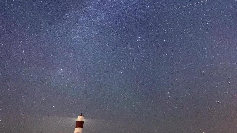 Eine Sternschnuppe ist am Sternenhimmel über dem Leuchtturm im britischen Happisburgh zu sehen. Infolge eines Meteoritenstroms, die sogenannten Perseiden, die jährlich in der ersten Augusthälfte wiederkehren, gibt es viele Sternschnuppen am Nachthimmel.