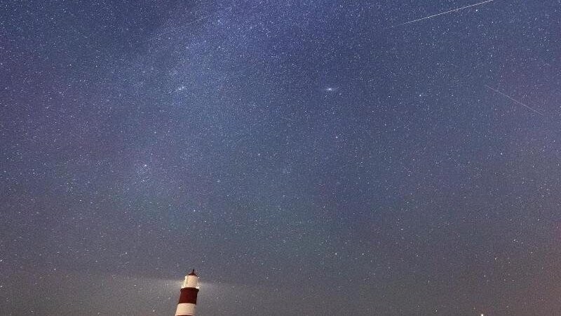 Eine Sternschnuppe ist am Sternenhimmel über dem Leuchtturm im britischen Happisburgh zu sehen. Infolge eines Meteoritenstroms, die sogenannten Perseiden, die jährlich in der ersten Augusthälfte wiederkehren, gibt es viele Sternschnuppen am Nachthimmel.