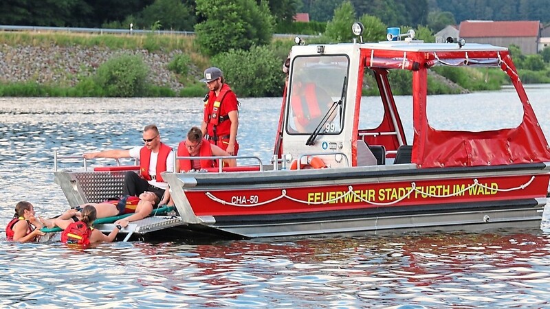 Mit Hilfe eines Combi-Carriers bringen DLRG-Schwimmerinnen eine "ohnmächtige" Frau über die Bugklappe aufs neue Boot der Further Feuerwehr. So können Personen im Wasser künftig noch schneller und schonender gerettet werden.