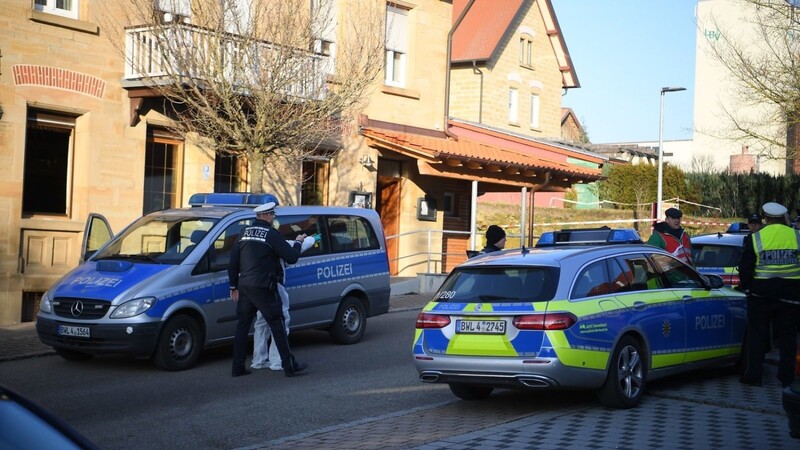 Nach Schüssen in Rot am See im Nordosten Baden-Württembergs stehen Polizeiautos an einem Haus. Hier sollen mehrere Menschen getötet worden sein.