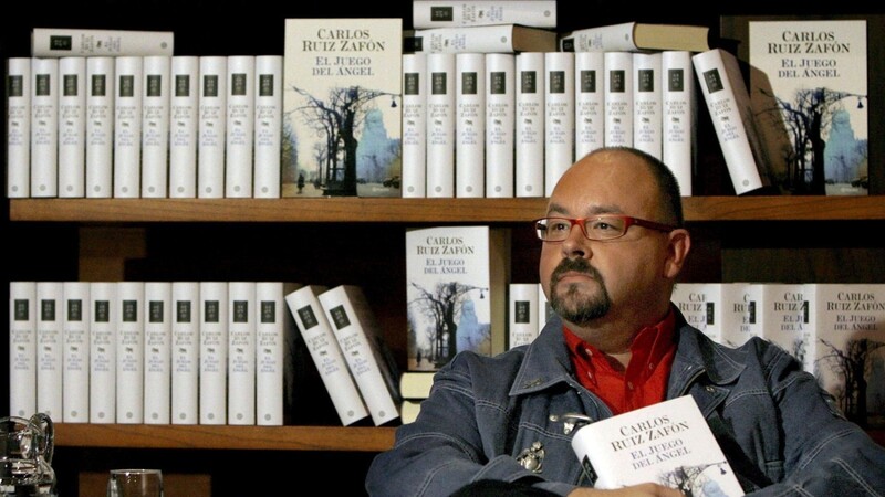 Der spanische Bestseller-Autor Carlos Ruiz Zafon sitzt vor einer Bücherwand. Zafon ist im Alter von 55 Jahren in Los Angeles gestorben. Er sei an Krebs erkrankt gewesen, meldete die Nachrichtenagentur Europapress unter Berufung auf seinen Verlag Planeta am 19.06.2020. (Archivbild)