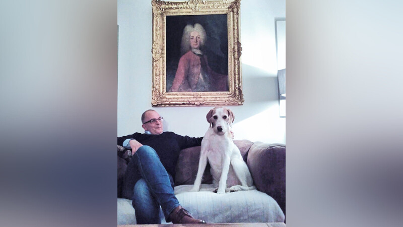 Mathias Wieland - mit Hund Dorian, vor Ahnenporträt.
