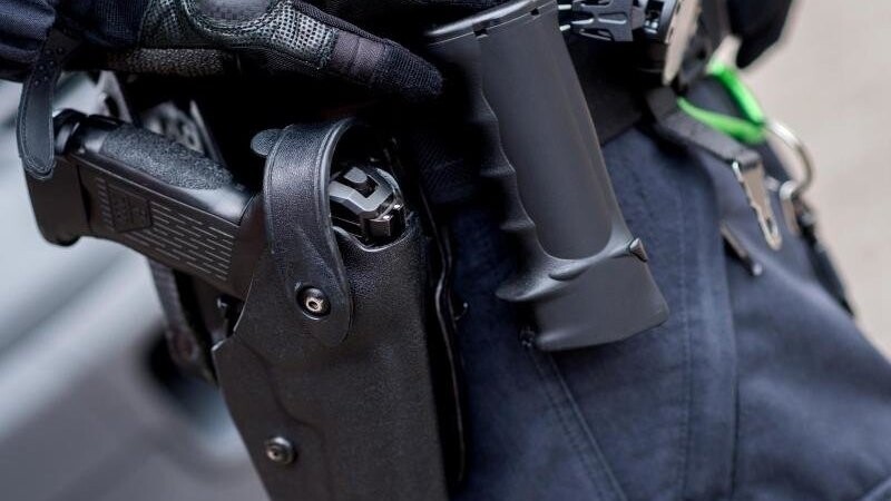 Ein Beamter trägt die Dienstwaffe am Gürtel. Foto: Hauke-Christian Dittrich/dpa