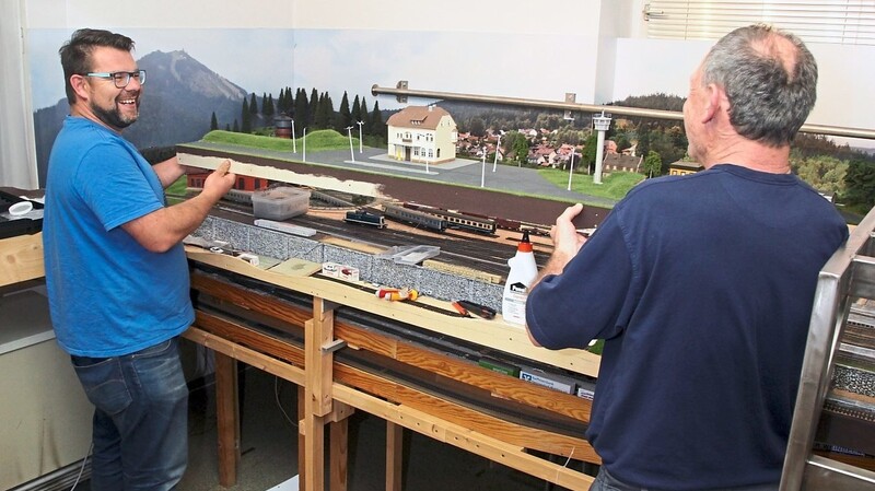 Die Vereinsräume der Modell-Eisenbahner erinnern an eine Atelier-Werkstatt. Robert Spanner (l.) und Jürgen Linnebach passen Geländeteile in den Unterbau ein. Gebaut wird unter strengen Corona-Regeln und unter Einhaltung der Mindestabstände.