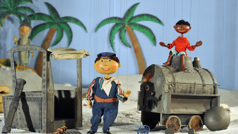 Generationen sind mit ihren Abenteuern aufgewachsen: Jim Knopf und Lukas der Lokomotivführer als Marionetten der Augsburger Puppenkiste, im Hintergrund: der Scheinriese Herr Tur Tur.