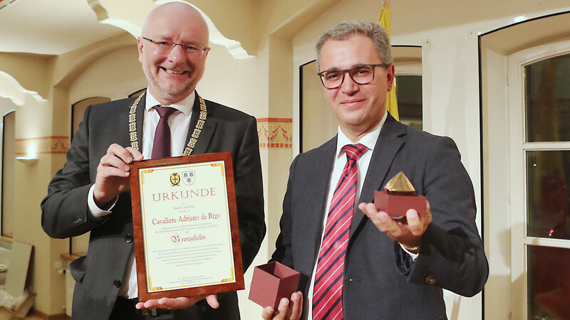 Der Partnerschaftsbeauftragte auf italienischer Seite, Adriano de Rigo, wurde von Landshuts Oberbürgermeister Alexander Putz (links) mit dem Bronzenen Helm und einer Ehrenurkunde ausgezeichnet.