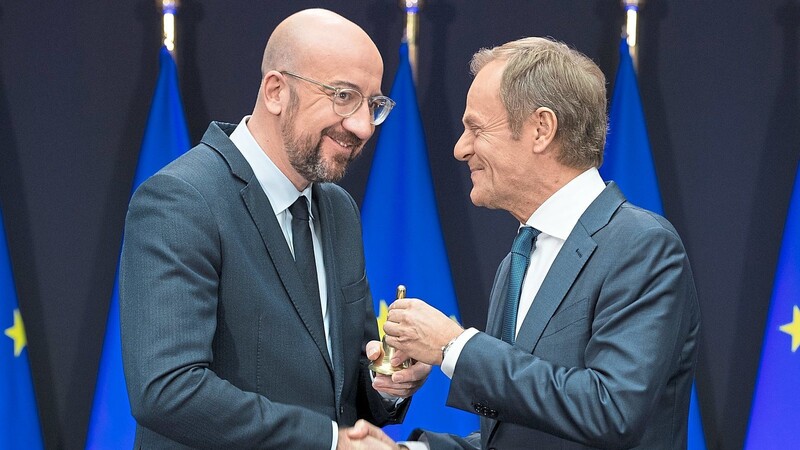 Charles Michel (l.), neuer Präsident des Europäischen Rates, und Donald Tusk, scheidender Präsident, reichen sich während des symbolischen Akts der Amtsübergabe die Hand, mit der anderen wird die Glocke überreicht.