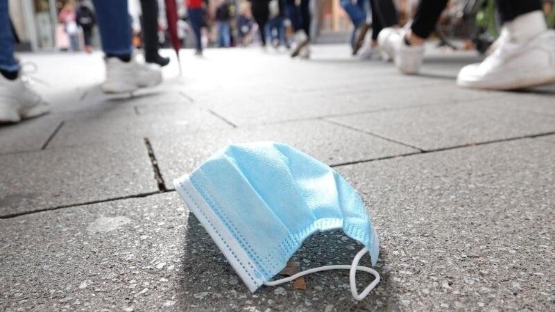 Ein auf dem Boden liegender Mund-Nasen-Schutz in der Kölner Innenstadt. Der Bund will eine ergänzende Maskenpflicht einführen.