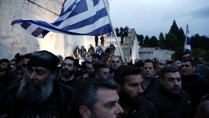 Landwirte halten in Griechenland die Nationalflagge hoch, während sie an einem Protest vor dem Parlament am 12. Februar in Athen teilnehmen. In ganz Griechenland haben sich Bauern zusammengeschlossen, um in einem Großaufgebot gegen stark umstrittene Reformpläne zu kämpfen.