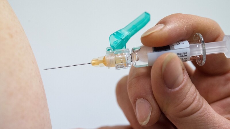 Ein Arzt impft jemanden gegen Grippe. Mit Blick auf eine mögliche neue Welle der Coronavirus-Infektionen im Herbst mahnen Ärzte schon jetzt für Risikogruppen zu bestimmten Impfungen.