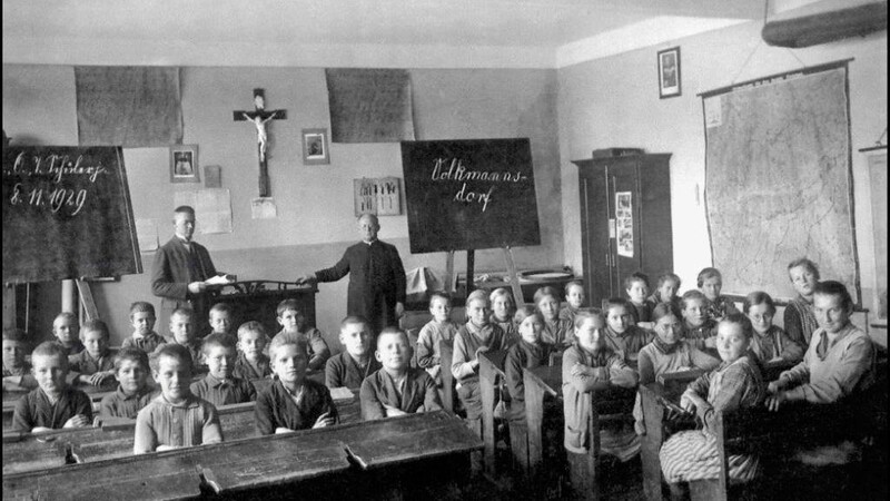 Eine Schulklasse an der Volkmannsdorfer Schule aus dem Jahr 1927. Im Hintergrund rechts Pfarrer Quirin Zacherl und links Karl Bergmeister.