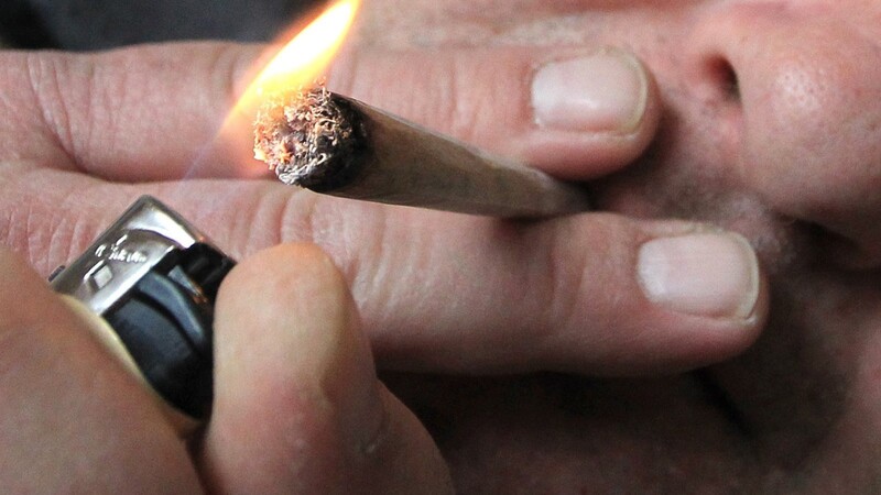 Ein Mann raucht eine selbst gedrehte Cannabis-Zigarette. Cannabis ist zu einem großen Problem geworden.