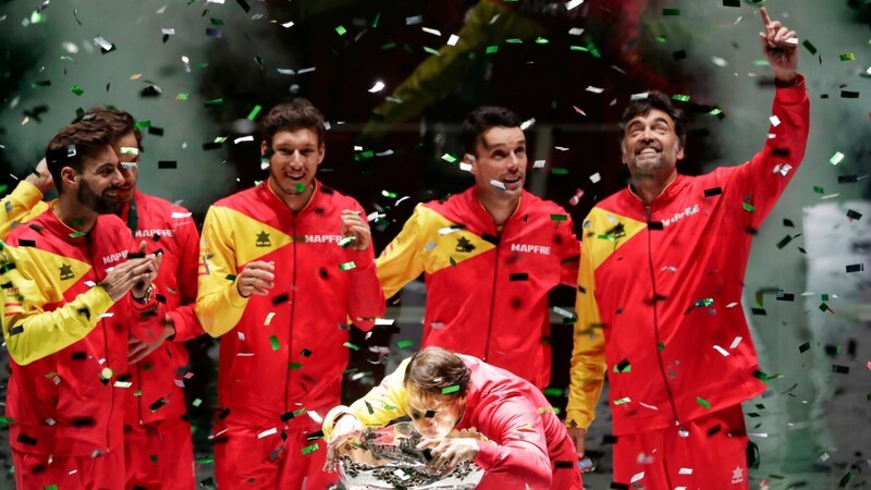 Die jubelnden spanischen Tennis-Herren präsentieren sich mit dem Davis Cup, während Rafael Nadal die Trophäe genauestens in Augenschein nimmt.