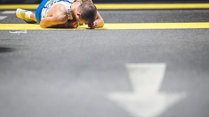 Hitze-Tortur: Beim Wettbewerb über 50 Kilometer Gehen liegt der Italiener Michele Antonelli erschöpft auf dem Asphalt.