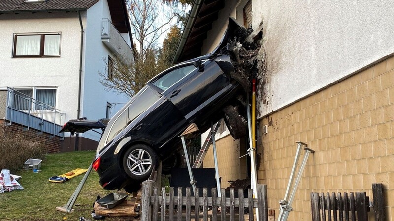 Ein Auto steckt nach einem schweren Unfall in einer Hauswand.