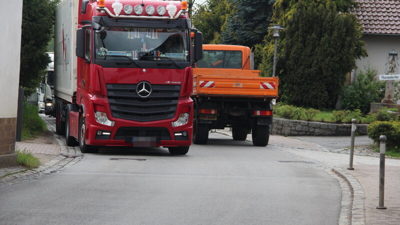 Eine Kolonne von Lastwagen fährt aufgrund der Umleitung rund um die Uhr durch den Ortskern von Haselbach. Sich mit dem eigenen Fahrzeug seitlich vorbeizuquetschen, ohne dabei den Bürgersteig zu versperren, ist beinahe unmöglich.