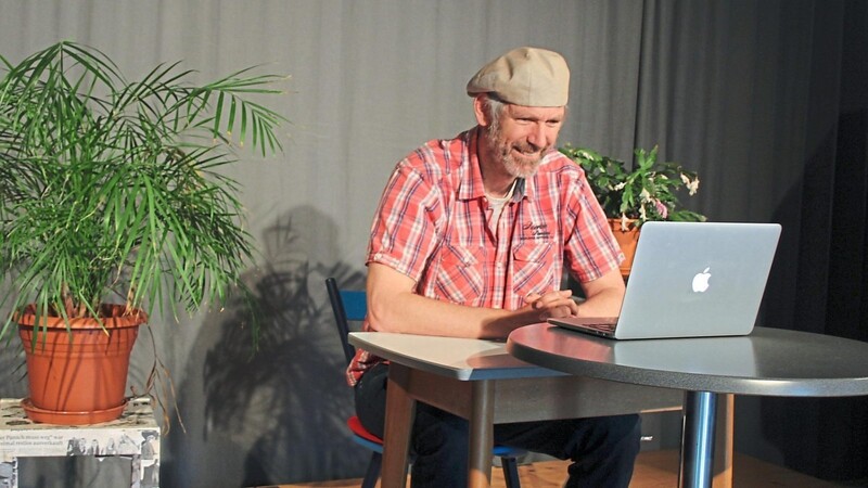 Franz Bauer auf der Bühne und vor dem Laptop.
