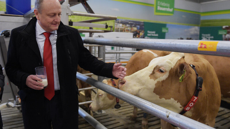 Joachim Rukwied, Präsident des Deutschen Bauernverbandes, steht mit einem Glas Milch in der Hand am 13.01.2016 vor Beginn der Grünen Woche im Bereich des sogenannten Erlebnisbauernhofs auf dem Messegelände in Berlin bei einer Milchkuh. Die Internationale Grüne Woche findet vom 15. bis zum 24.01.2016 statt.
