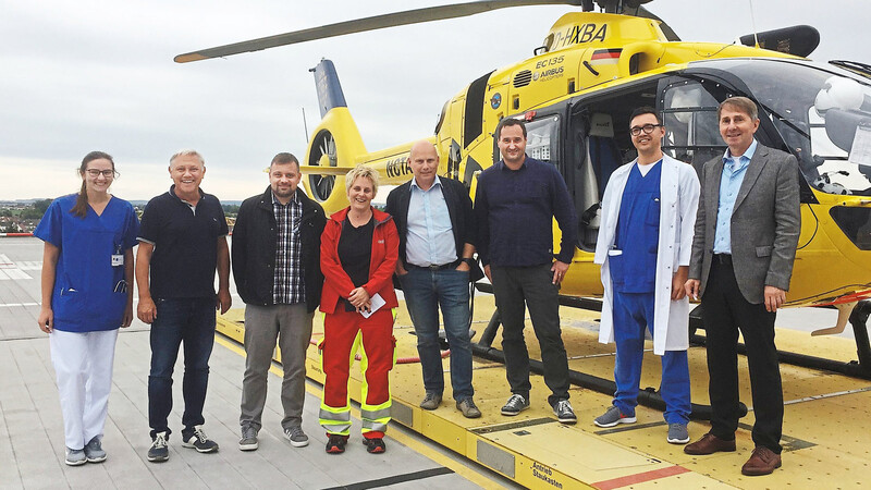 Die Besuchergruppe aus Slowenien mit Ärzten des Klinikums St. Elisabeth sowie Dr. Albert Solleder (2.v.l.) und Prof. Gerhard Nadler (rechts) vor dem Rettungshubschrauber auf dem Klinikdach.