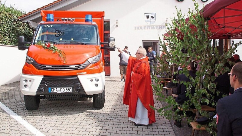 Der Ortsgeistliche, Pfarrer Augustin Sperl, segnet das neue Fahrzeug der FFW Oberndorf.