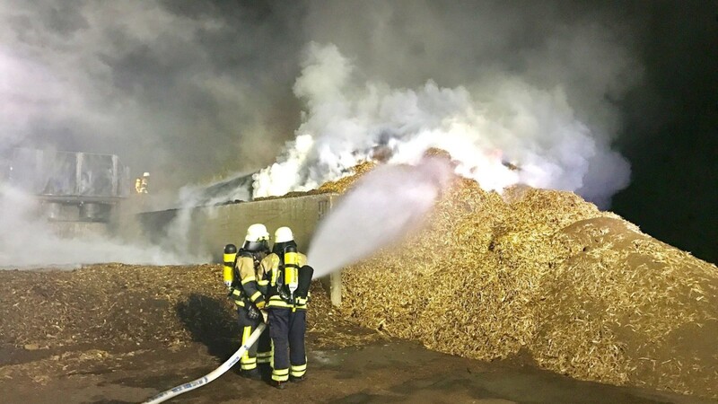 Arnschwanger Feuerwehrmänner beim Ablöschen der brennenden Hackschnitzel.
