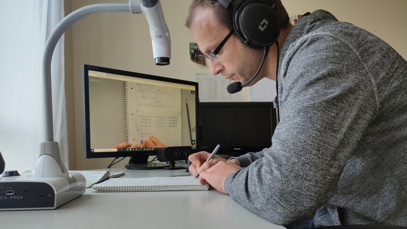 Mit Dokumentenkamera, PC und Headset hält Lehrer Josef Weindl Kontakt zu seinen Schülern.