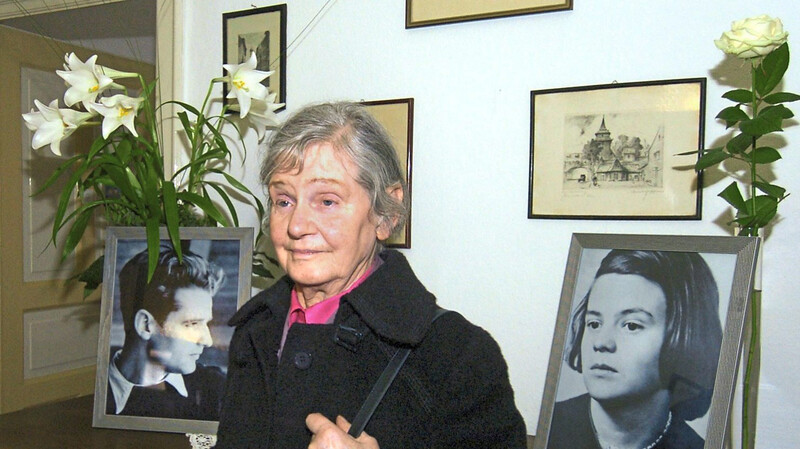 Elisabeth Hartnagel 2005 in der ehemaligen Wohnung ihrer Eltern in Ulm vor Fotos ihrer Geschwister Hans und Sophie Scholl.